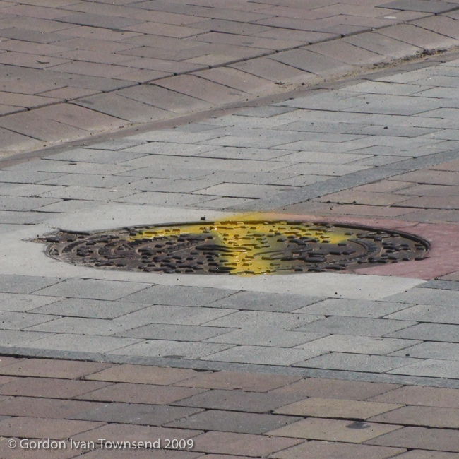 View SW along Calle Mayor (El Camino) towards hand-painted yellow-arrow way-marker (on manhole cover) - Villava - Day 3